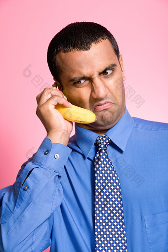 粉色调拿香蕉的职员摄影图