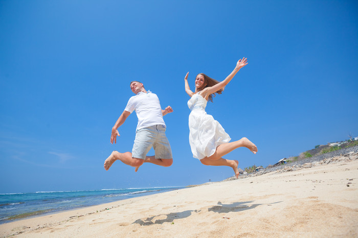 情侣海边沙滩跳跃欢快男子女子外国度假