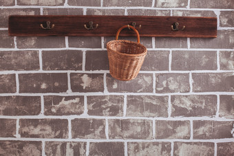 砖墙挂架上的棕色竹篮