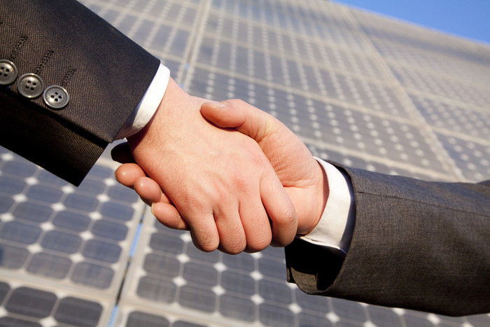 太阳能面板边握手的手