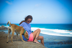 小女孩狗狗海边沙滩度假旅游风景背景摄影图