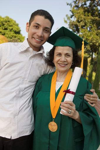 拿着毕业证书的妈妈和儿子