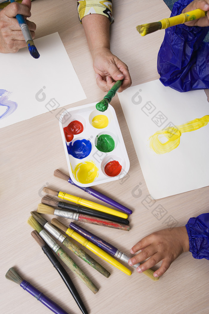 儿童拿着画笔蘸着颜料