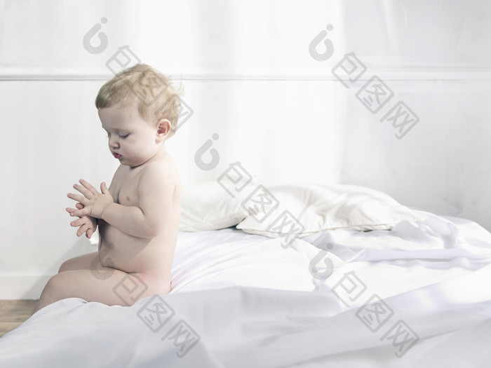 灰色调床上的小婴儿摄影图