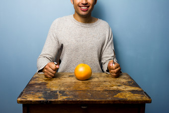 蓝色调吃橙子的男人摄影图