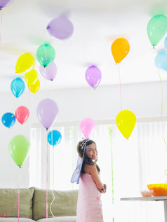 女孩站在充满气球的室内