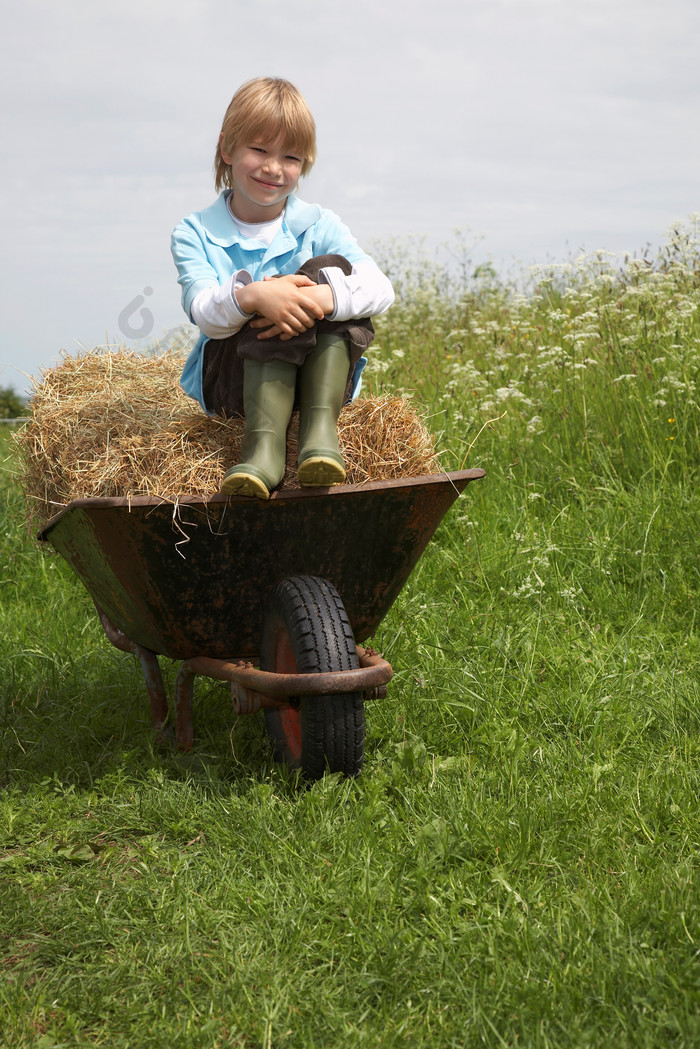 坐在推车稻草上的孩子