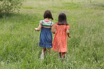 绿色调草地上的两个孩子摄影图