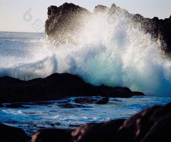 深色调冲击礁石的<strong>海浪</strong>摄影图