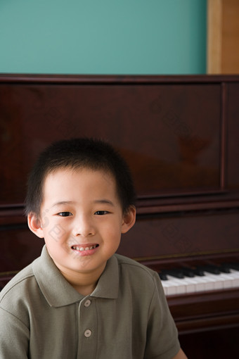 暗色调钢琴旁的男孩摄影图