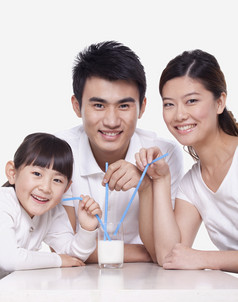 幸福一家三口爸爸妈妈女儿喝牛奶吸管家庭