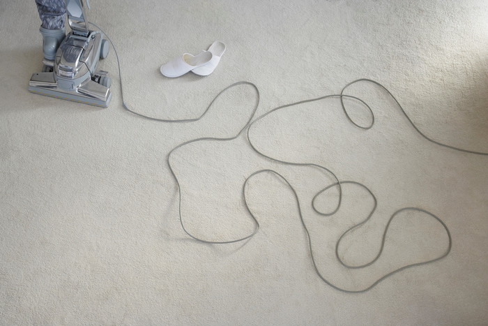 地毯上的吸尘器和拖鞋