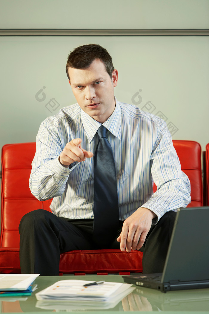 商务男士坐着沙发伸手指