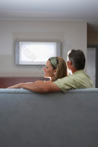 暗色调看着电视的夫妻摄影图