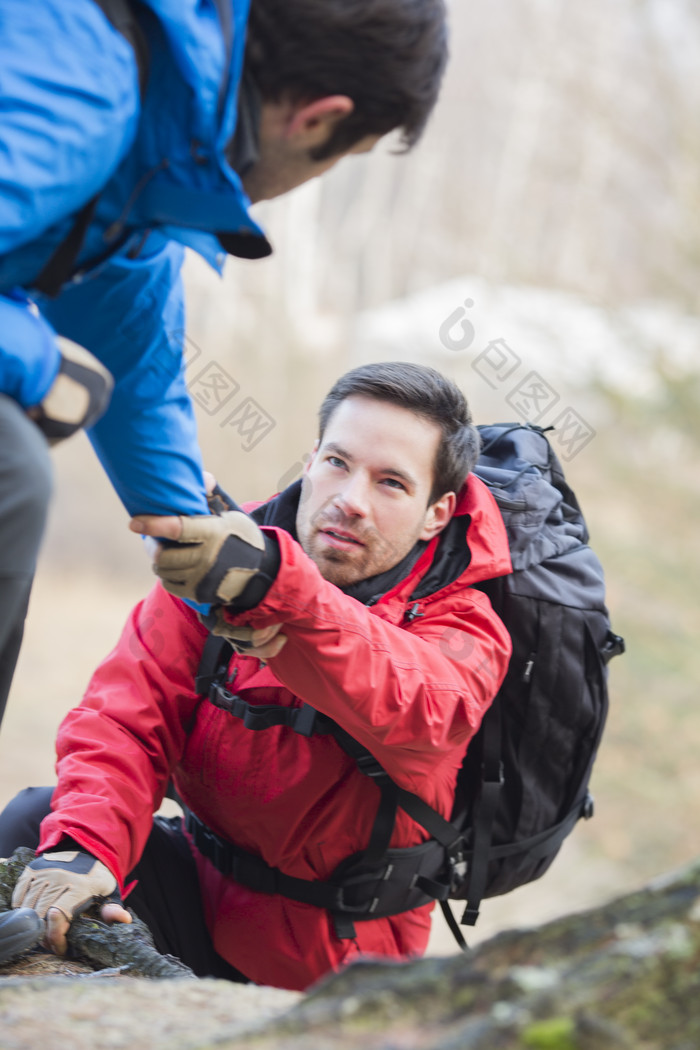 深色调登山互助摄影图