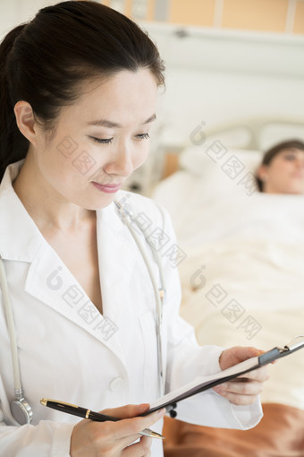 医生站在病床前查看病人病历