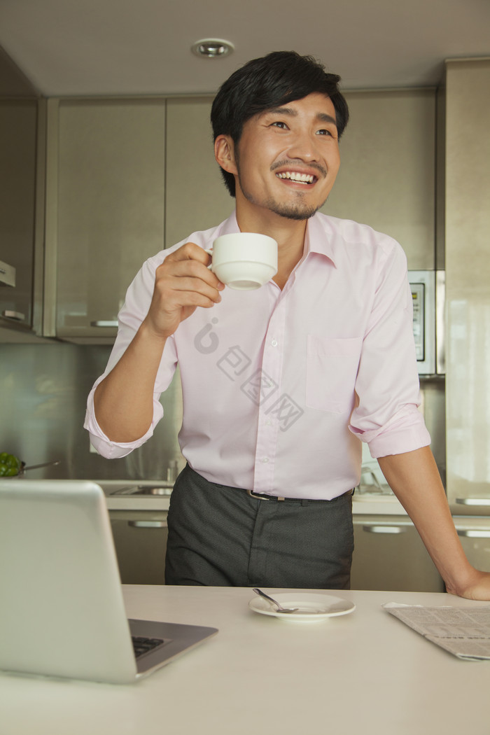 成熟的男人在家办公工作喝咖啡笔记本电脑衬图片