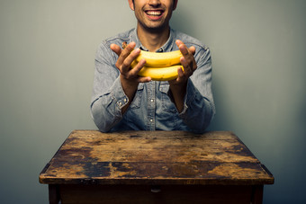 简约拿香蕉的男人摄影图