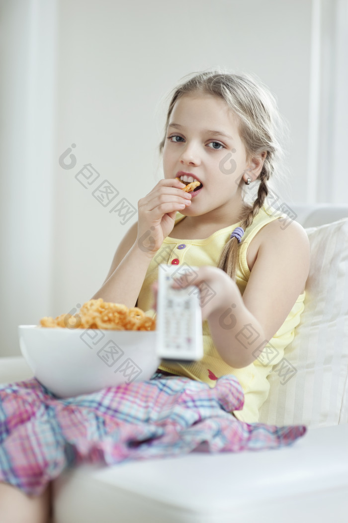 吃零食看电视的小女孩