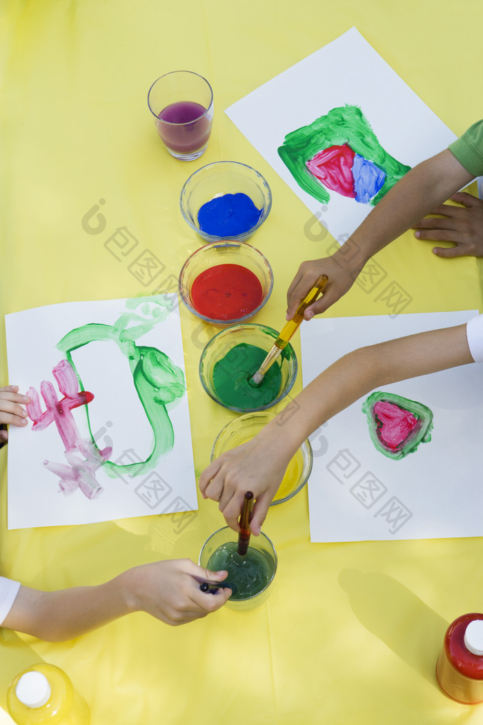 画笔蘸颜料画画的儿童