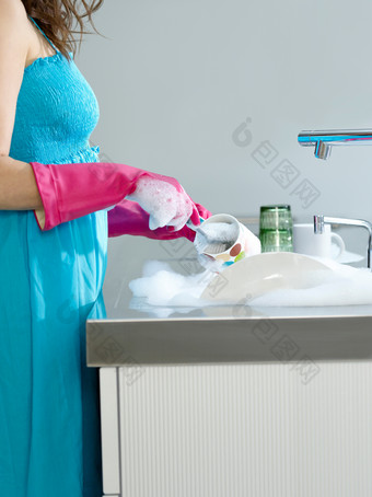 深色调洗碗的女人摄影图