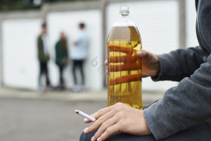 街边一个人手中拿着一瓶酒图片