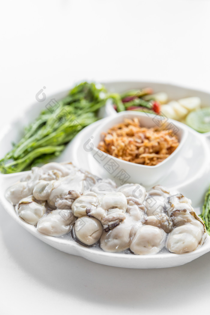 白盘里的海鲜牡蛎青菜食材