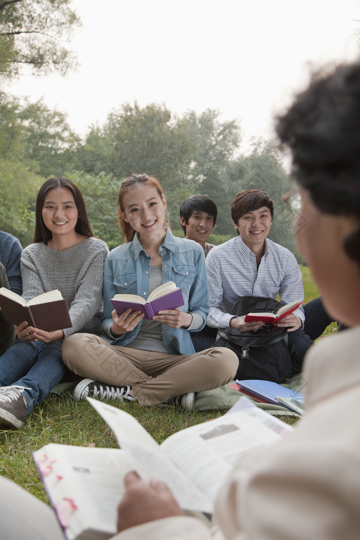 草地上读书群体女生老师学生开心的大学生