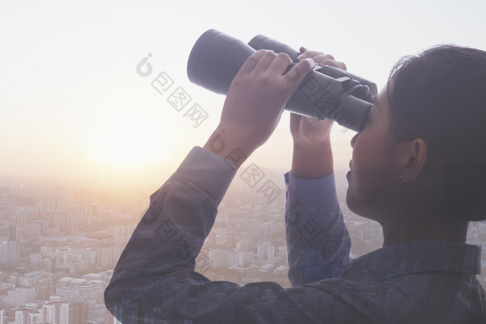 男人举着双筒望远镜眺望远方高楼大厦城市