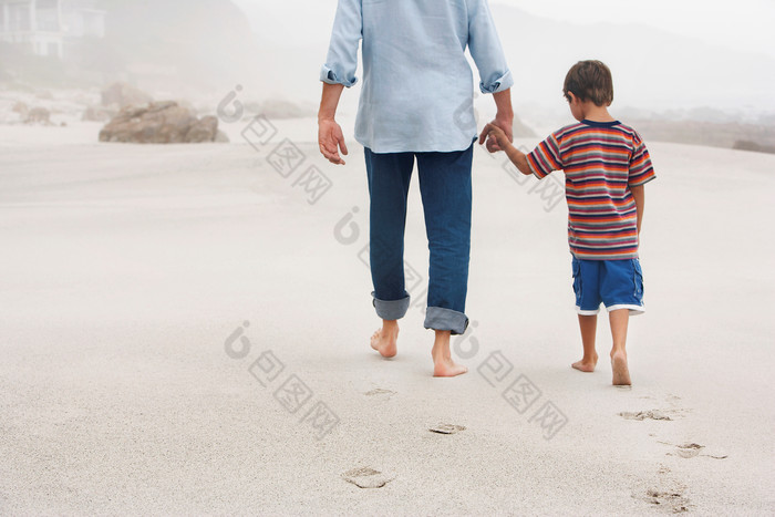 沙滩散步的父子背影