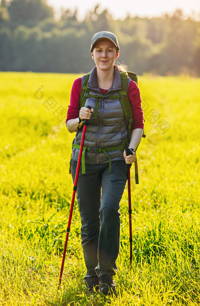 草地徒步旅行的女人摄影图
