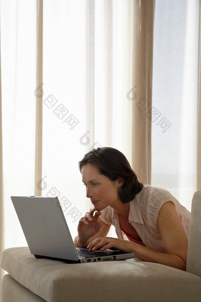 女人趴在床上玩电脑