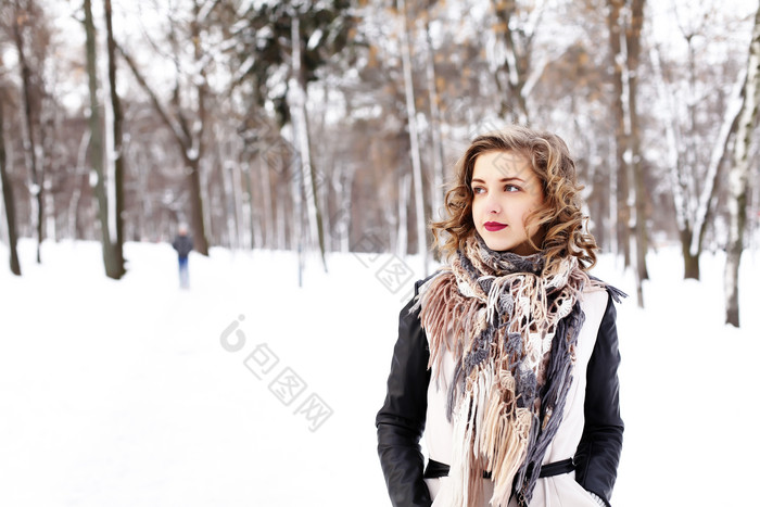 卷发美女站在树林雪地里