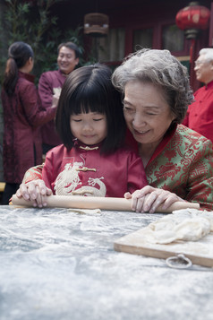 祖孙一起擀饺子皮摄影图