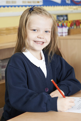 女孩坐在教室开心写字