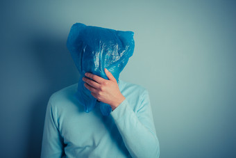 蓝色调戴塑料袋的男人摄影图