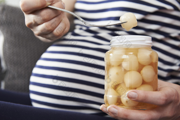 暗色调吃东西的孕妇摄影图