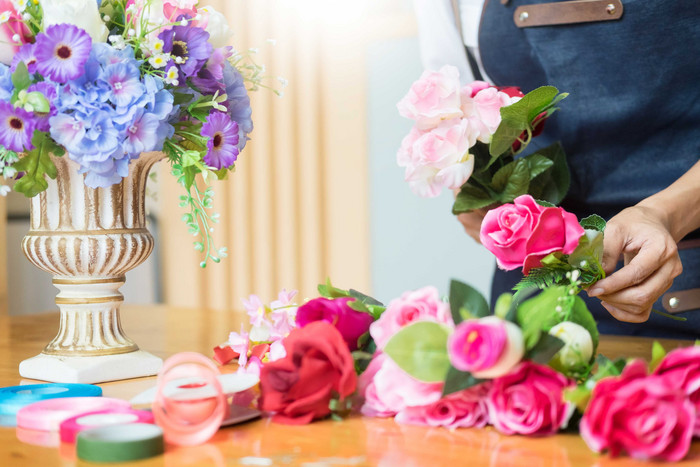 包玫瑰花花束的花艺师摄影图