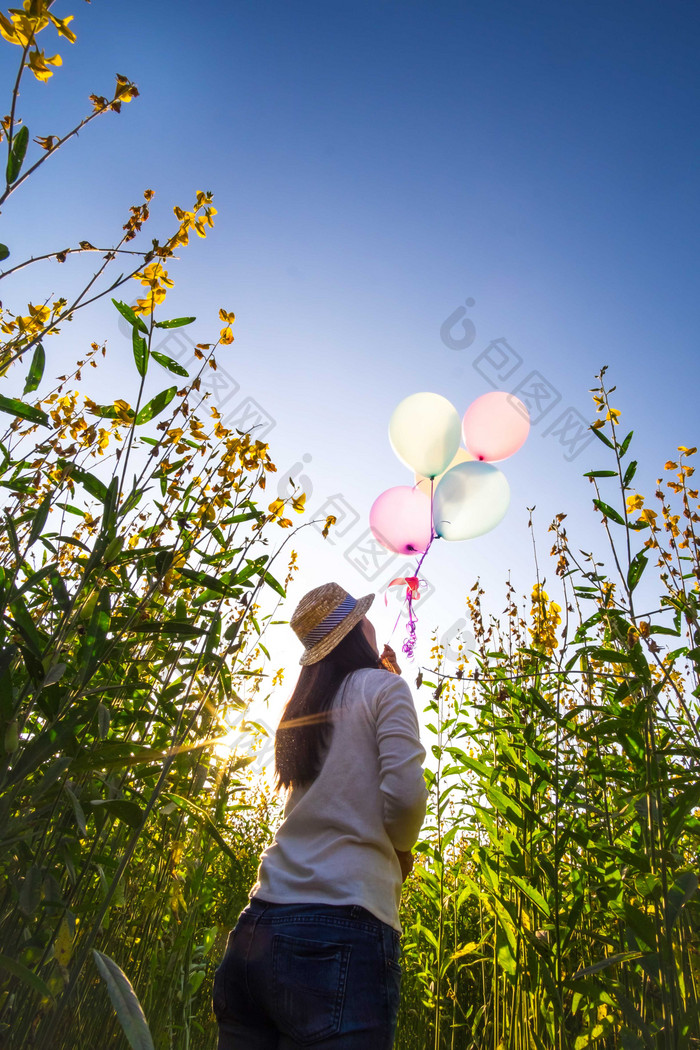 草丛中放飞气球的女人