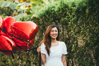 拿着气球开心的女人摄影图