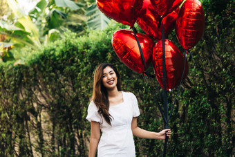 树林林拿着气球的女人摄影图