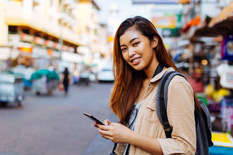 街道上玩手机的女人摄影图