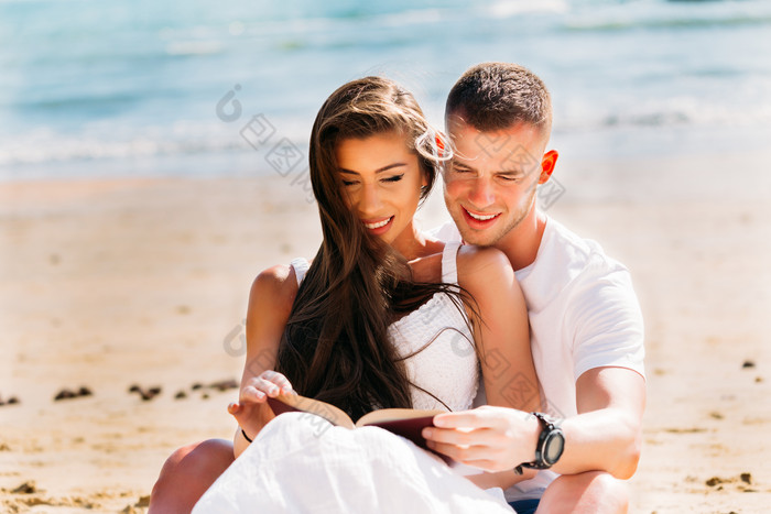 情侣沙滩看书摄影图