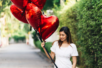 拿着心形<strong>气球</strong>的女人摄影图