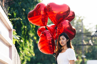 阳光下的女人拿着心形气球