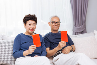 中国夫妇坐在沙发上拿着红包