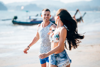 沙滩边奔跑的情侣摄影图