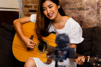 坐着弹吉他的女人摄影图