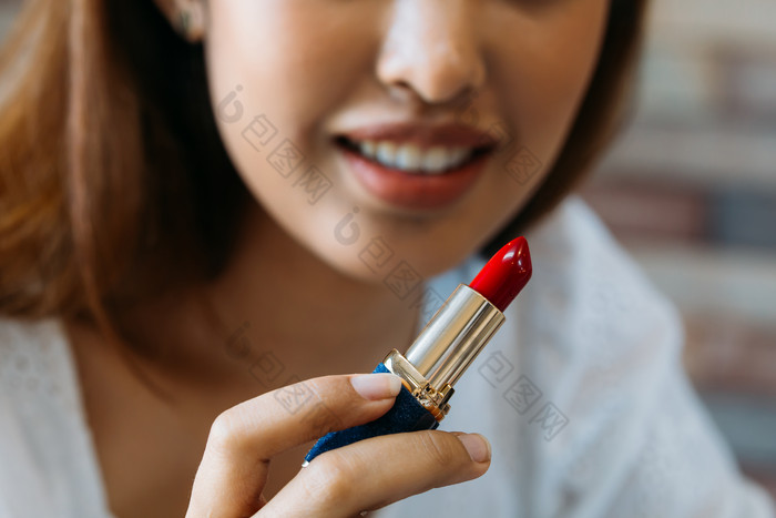 手拿口红化妆的女人