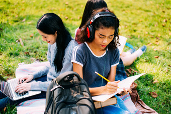 坐在草坪上学习的女孩们